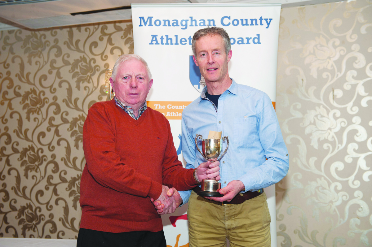 Winner of the Mens 50+ Road League, Mark Macklin, Monaghan Town Runners, being presented with the cup by Patsy Kelly. Â©Rory Geary/The Northern Standard