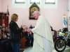 Fr John Kierans receiving a candle in memory of a deceased biker during the mass. Â©Rory Geary/The Northern Standard