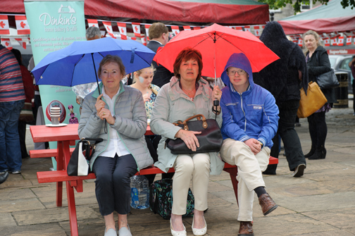 Taking shelter from the rain during the Monaghan Canada Day celebrations were (L-R) Peggy McElwaine, Violet and Mark McCabe. Â©Rory Geary/The Northern Standard